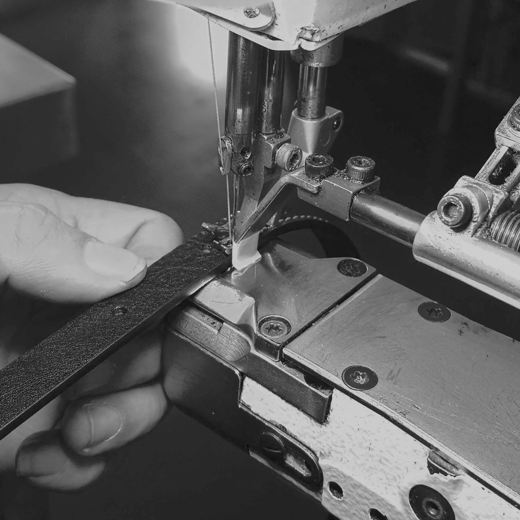 skilled artisan hand stitching each piece of leather